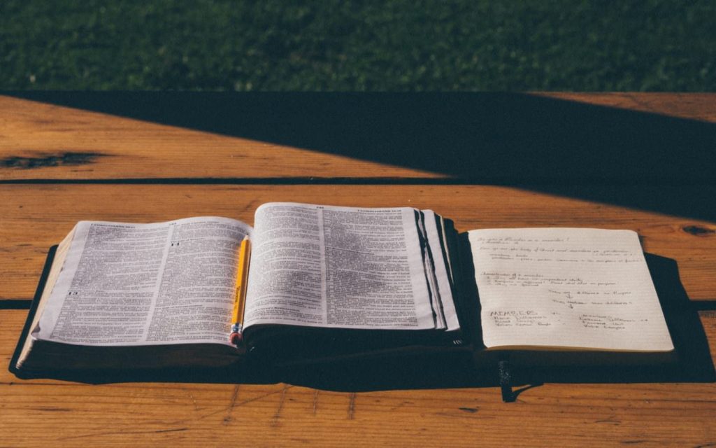 Photo of open Bible with notebook