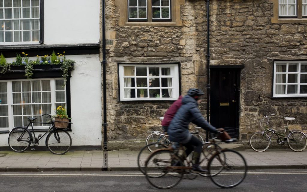 Photo of two friends biking together on a street
